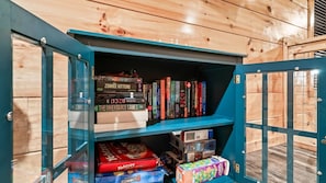 Ein Holzregal mit Büchern und Gesellschaftsspielen.