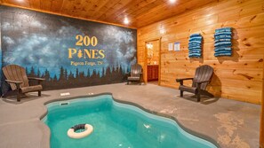 A pool area with Adirondack chairs, a mural, and a sign indicating '200 PINE' in Pigeon Forge, TN. - Scenic Log Retreat • HotTub, Indoor Pool & Dogs OK (Sevierville)