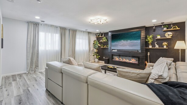 Un salon moderne avec un canapé, une cheminée et des étagères décoratives.
