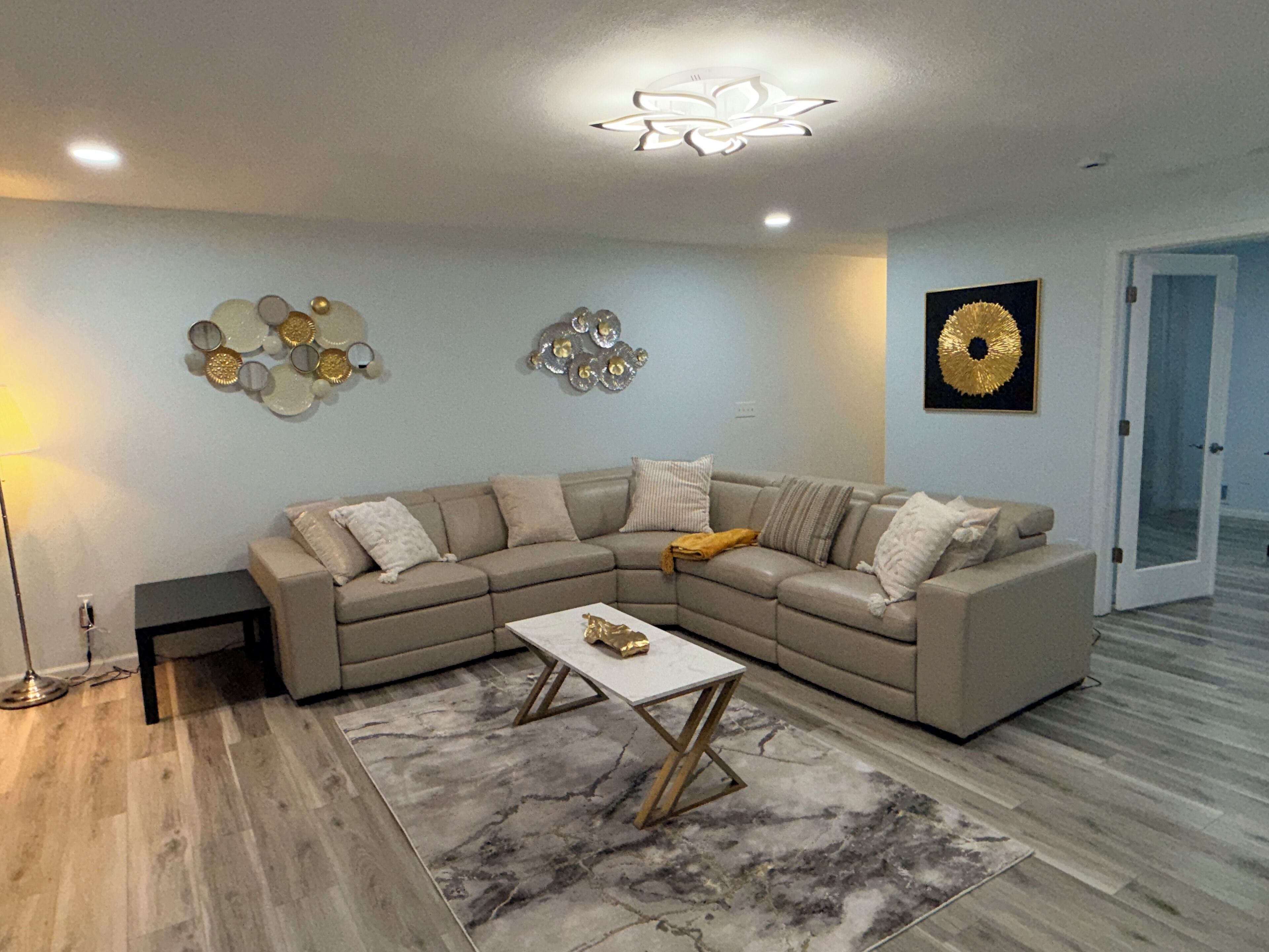 A modern living room with a sectional sofa, a coffee table, and decorative wall art.