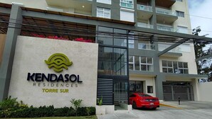 Un edificio moderno con un cartel que dice 'KENDASOL RESIDENCES TORRE SUR'.