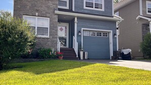 A two-story house with a stone facade, a front porch, and a garage. - Private Basement + Self Check-in + Kids/Family + Parking (Bedford)
