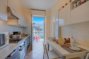 A compact kitchen with a view of a balcony and mountains. - Ambra lakeside retreat&view / Terrace, San Felice del Benaco, Italy (San Felice del Benaco)