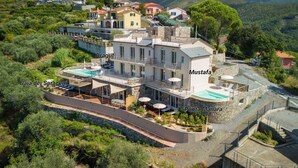 A multi-story building with a pool, named Punta Manara, surrounded by greenery and other buildings. - Relais Le Torri in Verici Baia Saraceni, Casarza Ligure, Italy (Casarza Ligure)