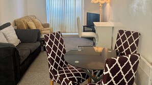 A living room with a sofa, two patterned armchairs, a small round table, a lamp, and a TV. - 2 Bed Wolverhampton Apartment-sleeps 5 (Wolverhampton)