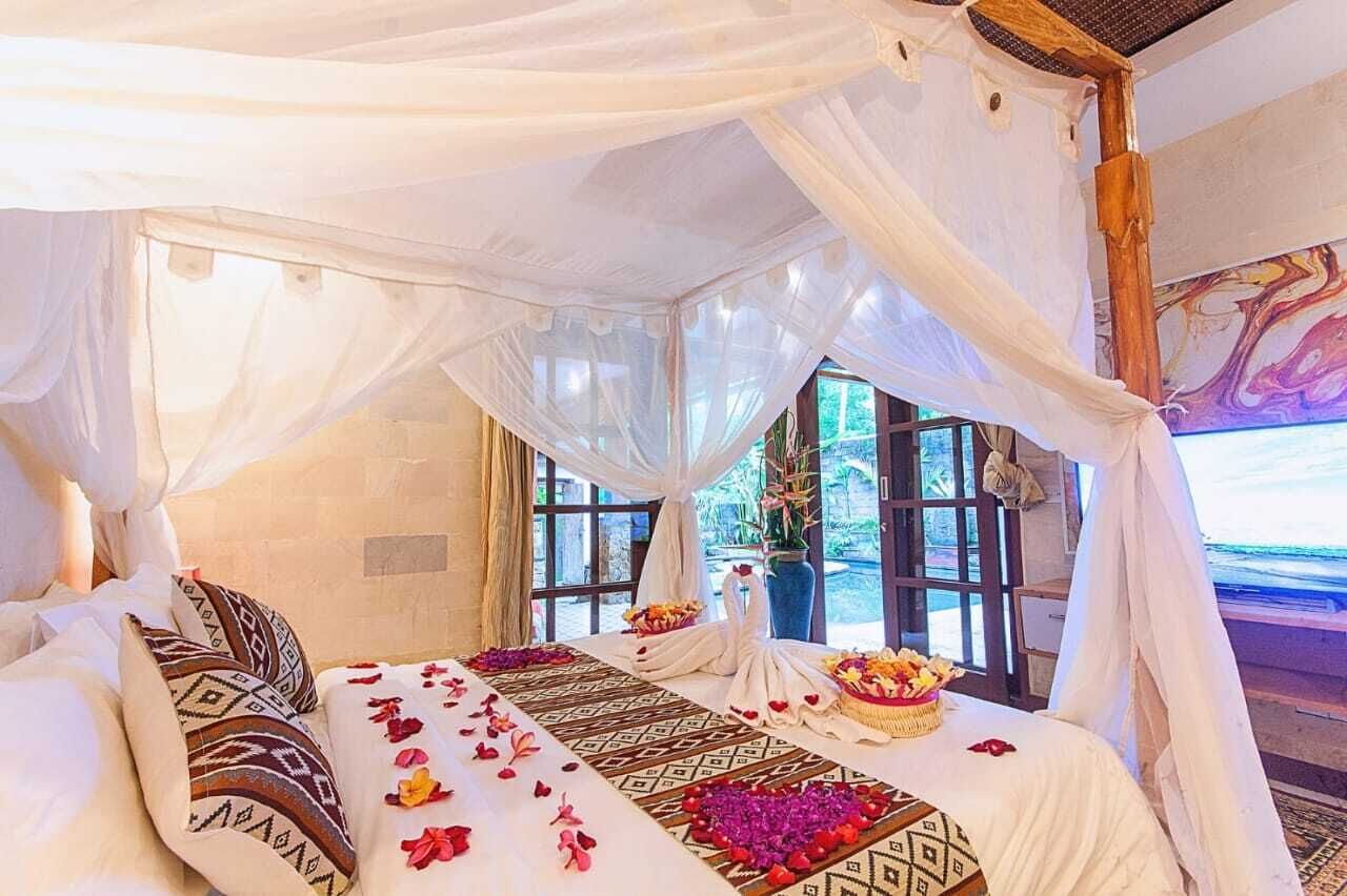 Una habitación con cama, dosel decorativo, ventanas amplias y vistas al exterior.