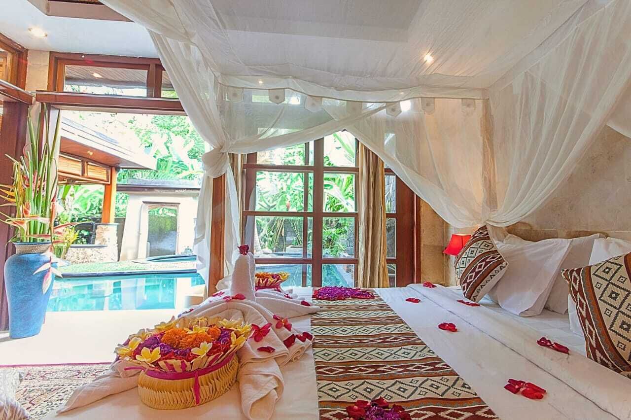 A room with a bed, a large window, and a view of a pool.