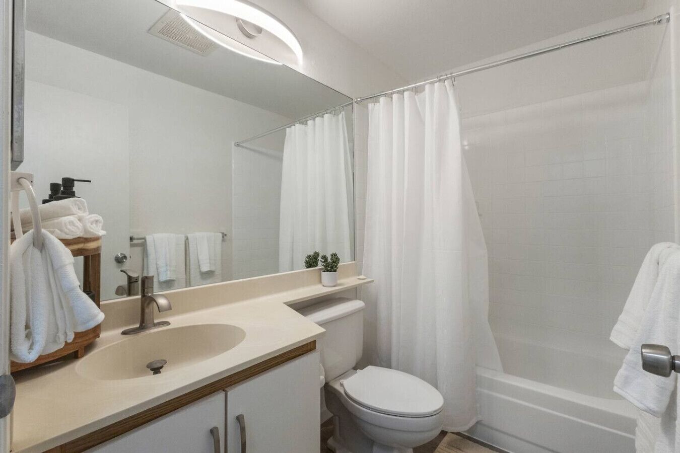 A modern bathroom with a sink, toilet, and shower.