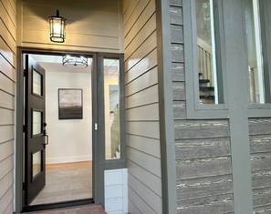 Une façade en bois avec une porte donnant accès à un espace intérieur.