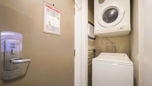 Een hotelkamer met een slot, een poster, een wasmachine en een droger.