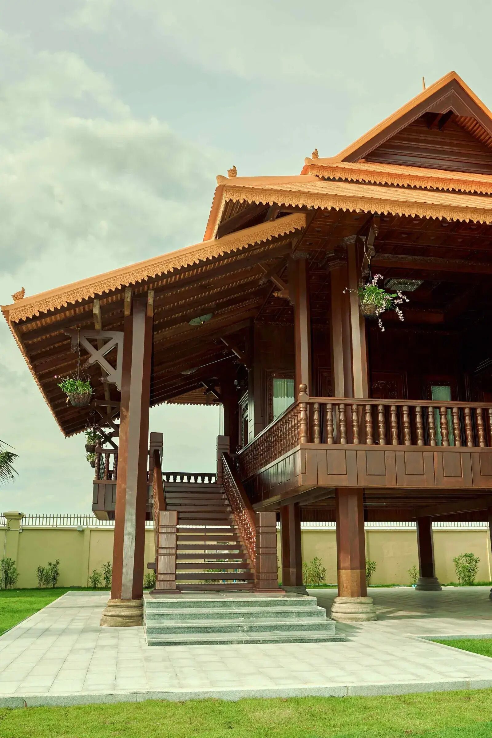 A traditional building with a covered porch, a staircase leading to the entrance, and a well-maintained lawn.