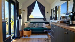 Una habitación acogedora con una cama, una mesita y una zona de cocina con cafetera.