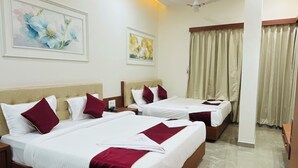 A hotel room with three beds, a ceiling fan, and a marble floor. - Hotel Park Inn  (Athni)