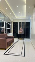 Um interior moderno com um sofá, uma estátua e uma parede refletora.