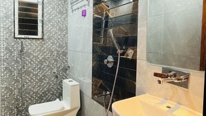 A bathroom with a toilet, bidet, sink, and shower. - Hotel Park Inn  (Athni)
