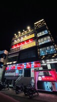 Um edifício com vários andares, com sinalização iluminada para um banco e um hotel.