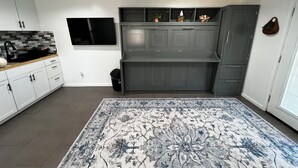 A modern kitchen with grey cabinets, a black ceiling fan, and a patterned rug. - Charming studio Backhouse in fantastic Amarillo great quiet neighborhood. (Amarillo)