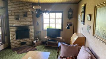 A cozy living room with a fireplace, television, and comfortable seating.