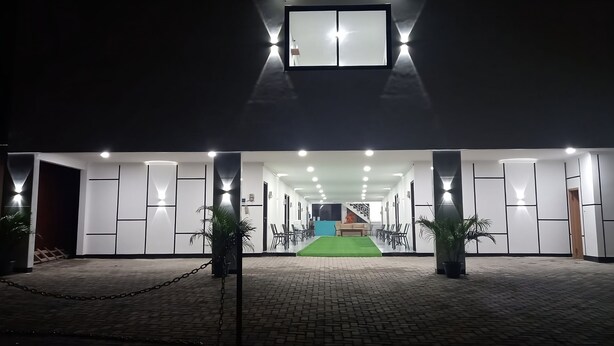 A modern hotel entrance with a green carpet, chain-link barrier, and a staircase leading to the upper floor. - Hotel Wisma Syariah (Jakarta)