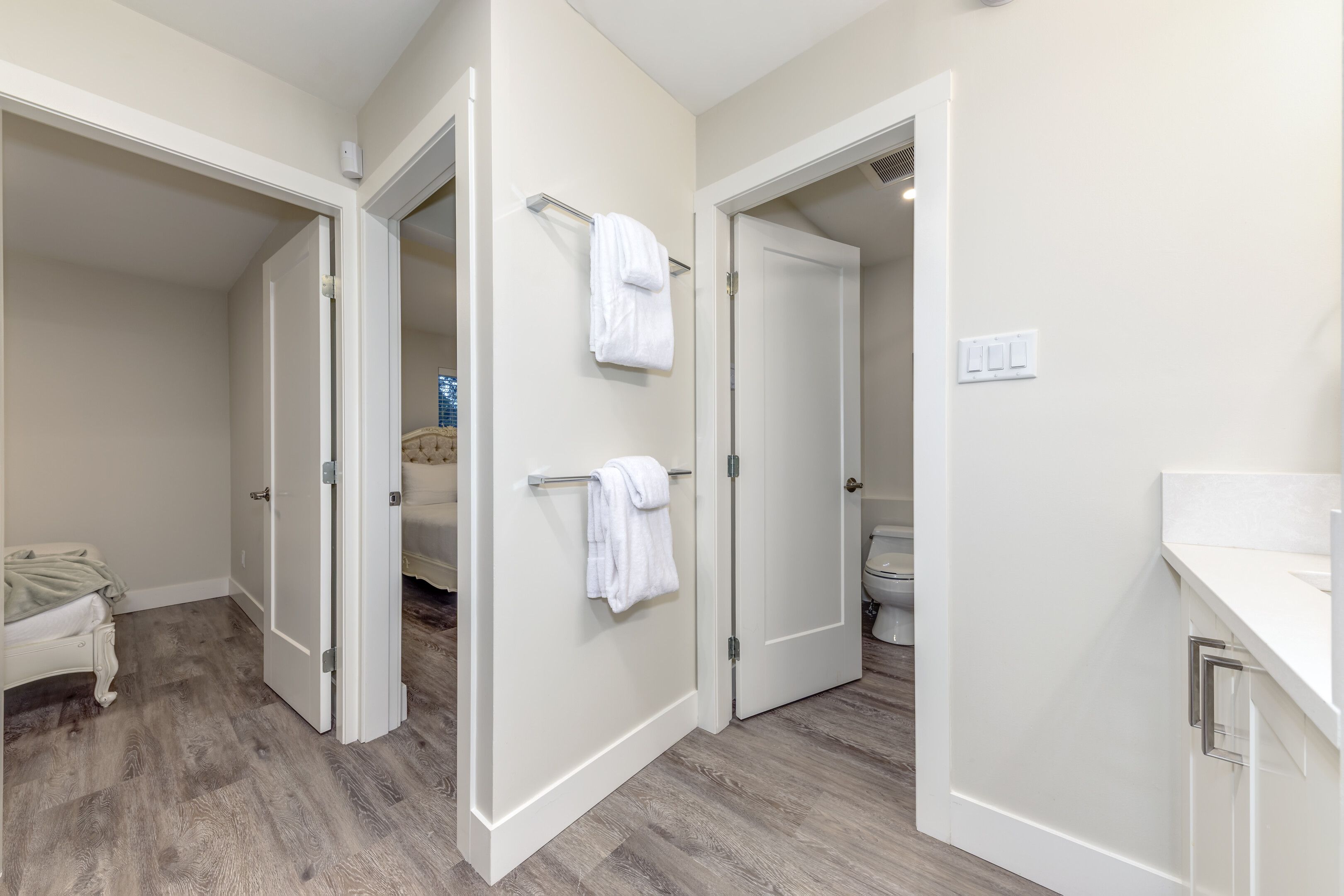 Un baño moderno con inodoro, lavamanos y perchero para toallas.