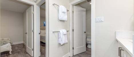 Un baño moderno con inodoro, lavamanos y perchero para toallas.