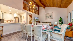 A dining area with a wooden ceiling, white walls, and a view of the kitchen. - Telemark 18 - Ski in Walk out,  Short Walk to the Village, New Listing! (Whistler)