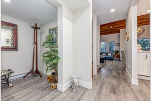 A hallway with a tall floor lamp, a potted plant, and a small elephant figurine.