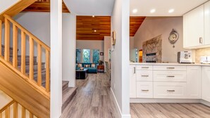 A modern kitchen with white cabinets and a wooden staircase. - Telemark 18 - Ski in Walk out,  Short Walk to the Village, New Listing! (Whistler)