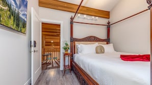 A bedroom with a four-poster bed, a wooden ceiling, and a painting of a mountain landscape. - Telemark 18 - Ski in Walk out,  Short Walk to the Village, New Listing! (Whistler)