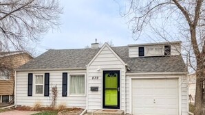 A single-story house with a green door, white garage door, and the number 839 on the front. - Sweet & Petite Midtown Cottage for 5-Long Stays Welcome (Billings)