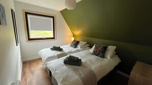 Un dormitorio con dos camas, una ventana, una lámpara y una luz en el techo.