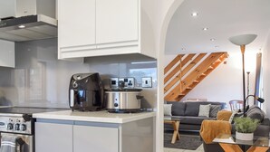 Uma cozinha moderna com uma ilha integrada, cafeteira e coifa de aço inoxidável.