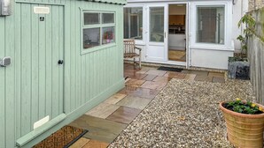 A green shed, a white conservatory, and a gravel patio with a potted plant. - 2 bedroom accommodation in Crook, near Bishop Auckland (Crook, near Bishop Auckland)