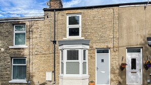 A two-story stone house with a bay window, a front door, and a small porch with steps. - 2 bedroom accommodation in Crook, near Bishop Auckland (Crook, near Bishop Auckland)
