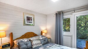 Una camera da letto con un letto in legno, due lampade sui comodini, un quadro appeso al muro e una finestra con tende.