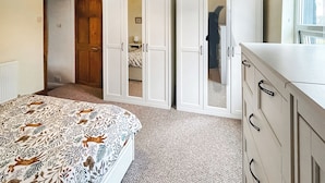 A bedroom with a bed, a wardrobe, and a dresser. - 2 bedroom accommodation in Arlecdon (Frizington)