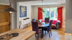 A dining area with a wooden table and chairs, a white cabinet with drawers, and a painting on the wall. - 3 bedroom accommodation in Ampleforth, near Helmsley (Ampleforth, near Helmsley)