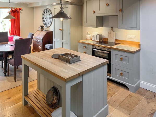 A kitchen with a central island, wooden cabinets, and a built-in oven.