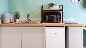 A compact kitchen with a sink, a microwave, and a dishwasher. - Hilltop Apartment 7 - UK50599 (Earl Shilton)