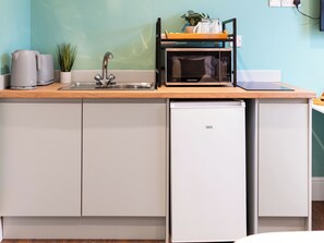 A compact kitchen with a sink, a microwave, and a dishwasher.