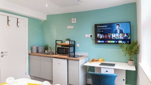 A modern room with a bed, a desk, a TV, and a small kitchenette. - Hilltop Apartment 7 - UK50599 (Earl Shilton)