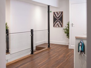 Ein modernes Interieur mit Holzboden, Glastrennwand und einem Gemälde an der Wand.
