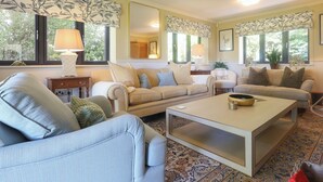 A living room with two sofas, a coffee table, and a mirror. - 4 bedroom accommodation in Royal Wootton Bassett (Royal Wootton Bassett)