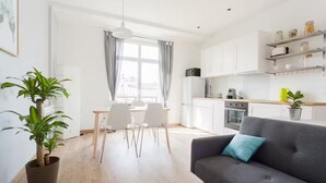 A modern apartment with a dining area, kitchen, and living room.