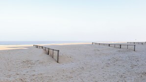 Une plage avec un sentier de sable et une clôture.