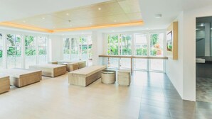 A spacious, modern interior with large windows, wooden furniture, and a clean, bright atmosphere. - Studio in Ozone Condo in Kata A702 (Karon)