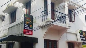 A multi-story building with balconies, a gated entrance, and a red carpet leading to the door. - Fort beach Residency (Kochi)