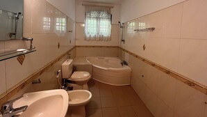 A compact bathroom with a toilet, sink, and bathtub. - Greenbell Kandy (Kandy)