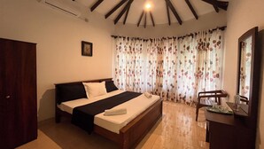 A bedroom with a bed, a wooden wardrobe, a desk with a mirror, and a window with curtains. - Greenbell Kandy (Kandy)