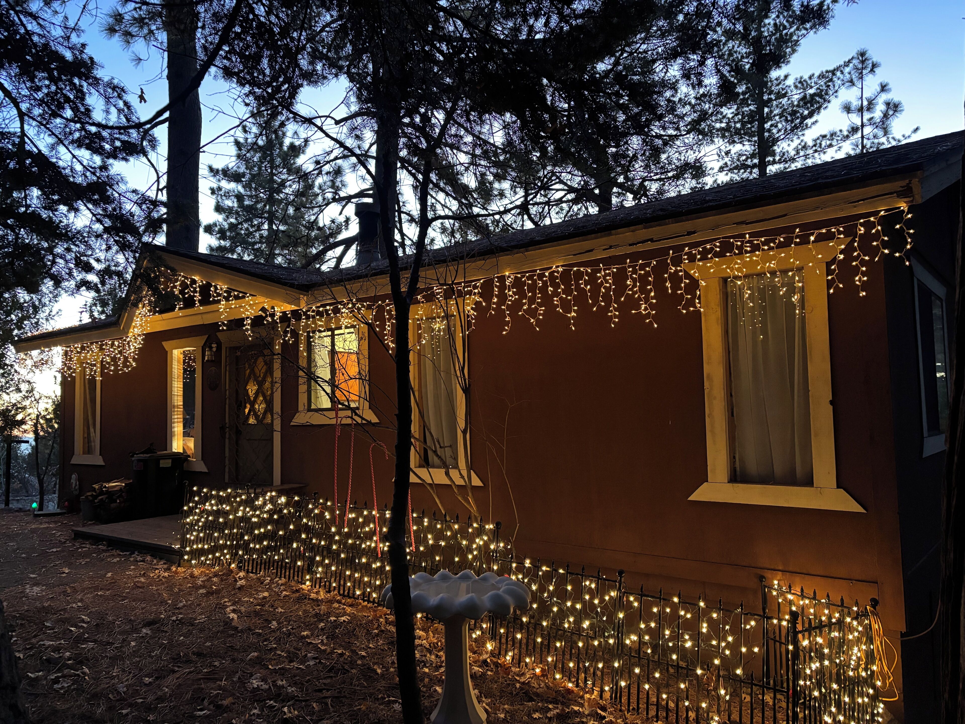 Front of cabin welcomes you with warm holiday lights.